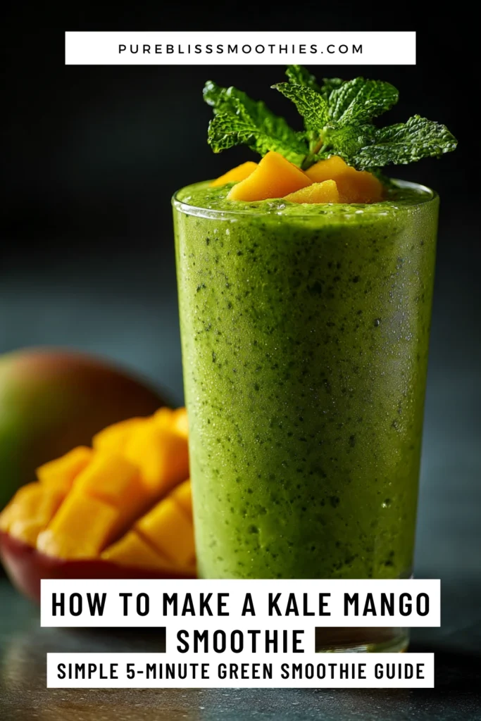 Tall glass of vibrant green kale mango smoothie garnished with fresh mint and mango chunks, with sliced mango and a whole mango in the background.